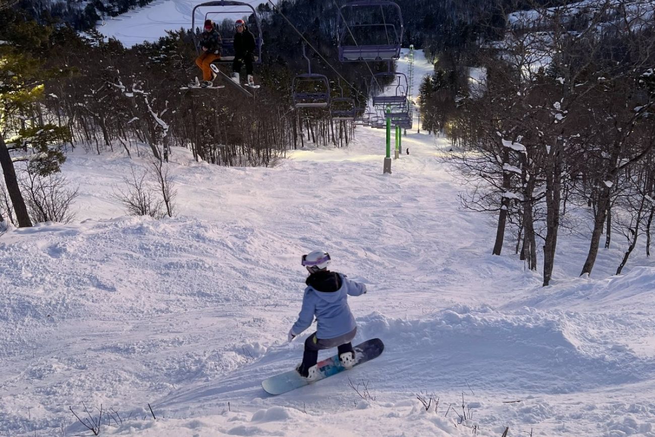 A snowboarder heads down a hill