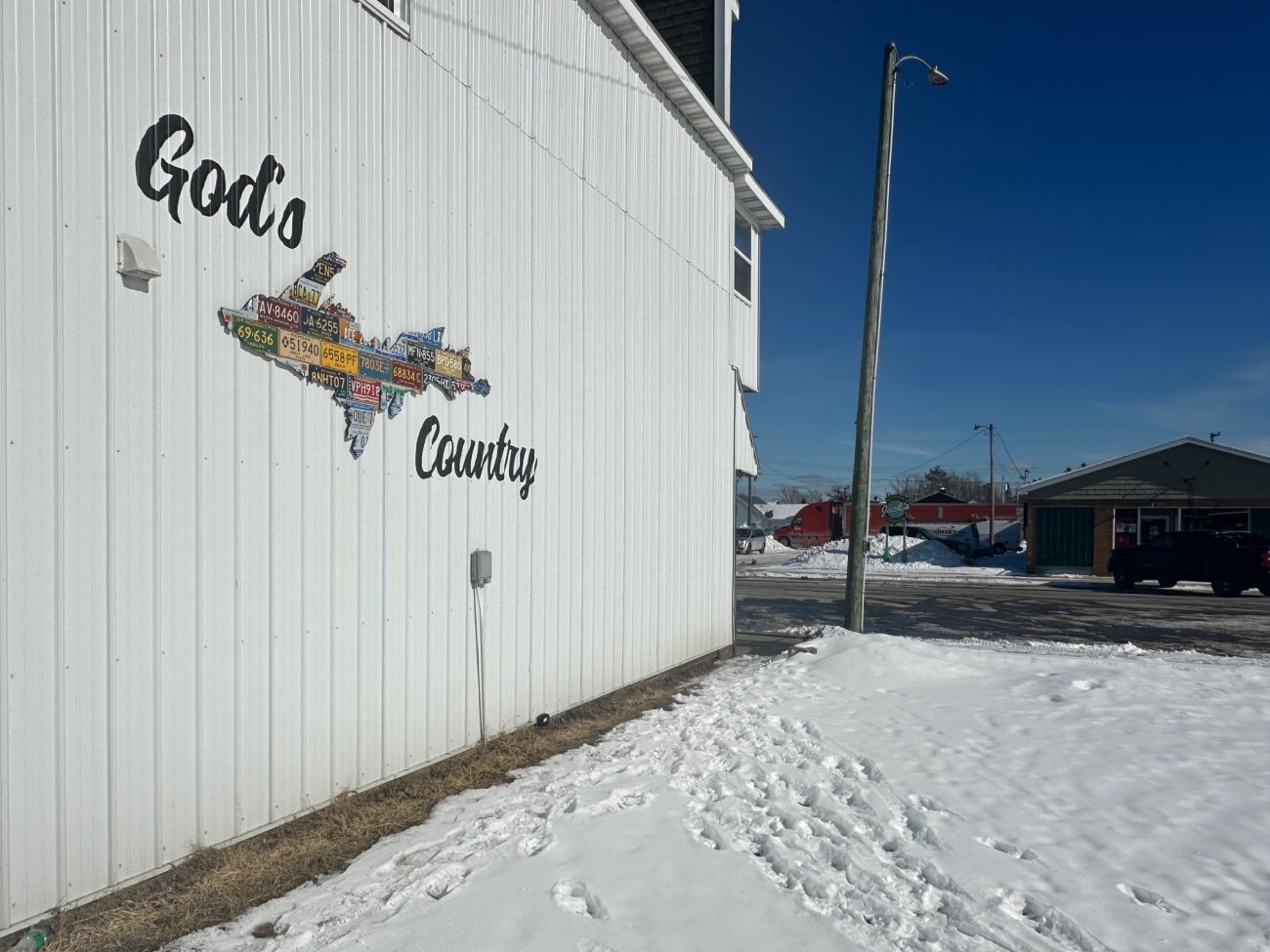 A sign on the side of the building that says"God's Country" with an outline of the UP.