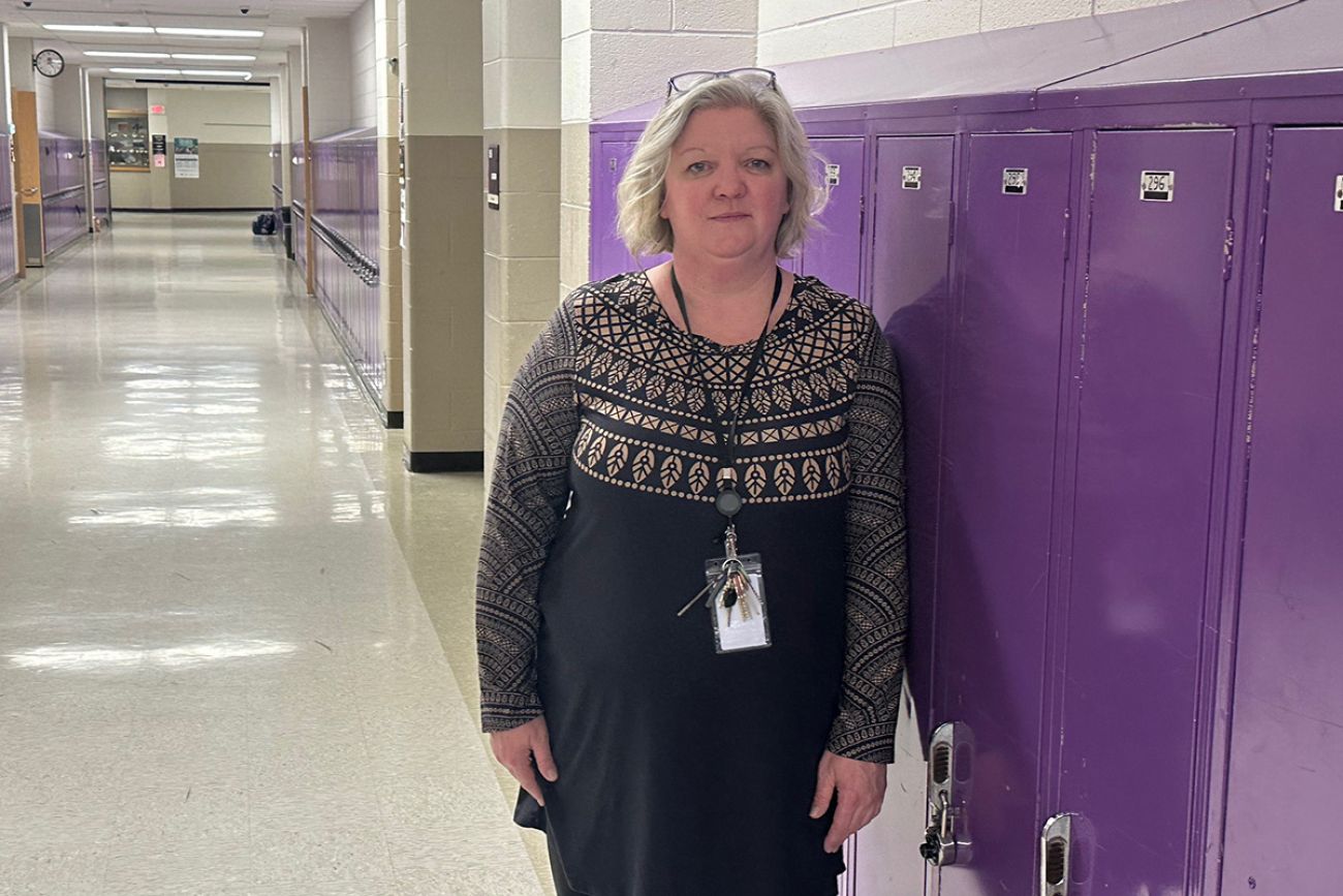 Rapid River School Principal Rachal Gustafson standing next to purple lockers.