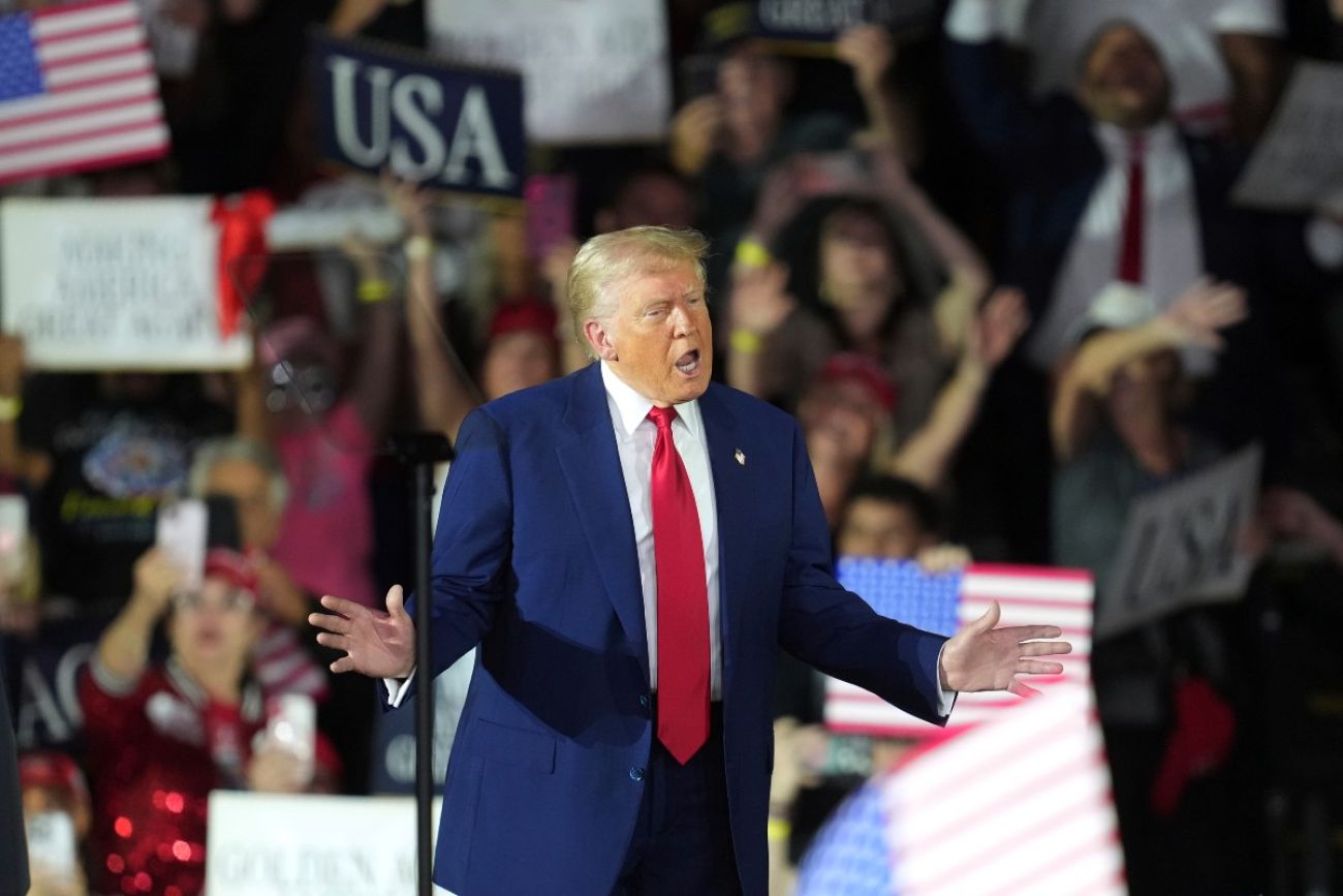 President Donald Trump waves to the crowd at a rally at Macomb Community College