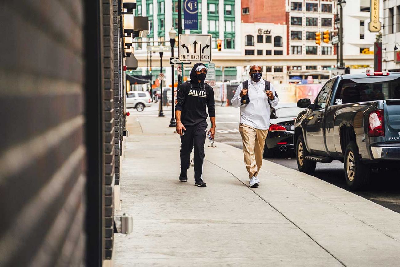 people wearing masks walking down the street