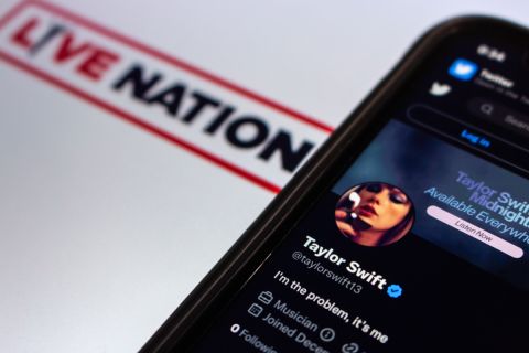 Phone screen shows Taylor Swift's X (formerly known as Twitter) profile on top of Live Nation flyer