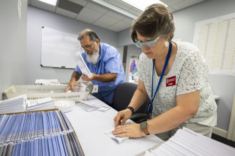 Dawn Stephens, right, and Duane Taylor preparing ballots on a white table