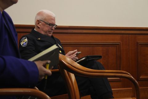 Jeff White, in his uniform, sitting in a chair. 