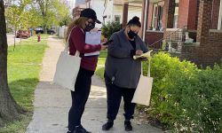 Elizabeth Gonzalez, left, and Nora Rodriguez go door-to-door on Ferdinand Street in Southwest Detroit to promote the availability of COVID-19 vaccines and to let neighborhood residents know where they can get them. 