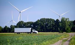 truck driving past wind turbines