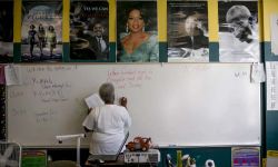 teacher in classroom writing on white board
