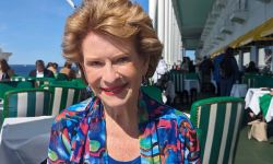 Debbie Stabenow, wearing a colorful shirt, sitting at the porch of the Grand Hotel