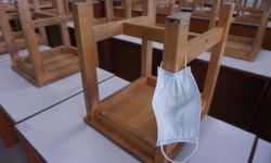 Mask hangs on chair in empty classroom