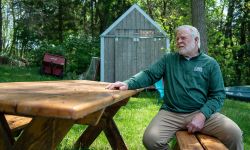  Dr. Glenn Dregansky, wearing a green sweatshirt, sitting at a bench