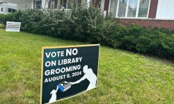 A sign in front of a home. The sign says "vote no on library grooming"