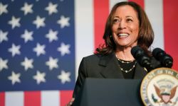 Kamala Harris speaking at a podium, American flag in the background