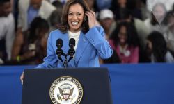  Vice President Kamala Harris, wearing a light blue jacket, speaking into a microphone