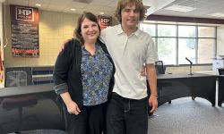 Mother and son posing for a picture together at the school board meeting room