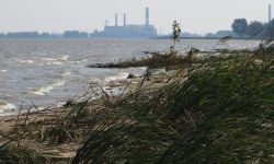 A beach with a power plant in the background