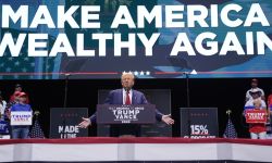 Former President Donald Trump at a rally, a sign in the back says "Make America Wealthy Again"