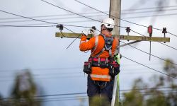 A linesman with a power company connects a new house in a rural area to the main network