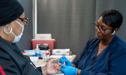 Patricia Adams, a registered nurse, pricks the finger of a patient at New Hope Missionary Baptist of Wayne