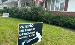 A sign in front of a house that says "Vote No On Library Grooming" 