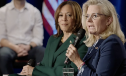 Republican former U.S. Rep. Liz Cheney is sitting down, speaking into a microphone. Kamala Harris sits next to her