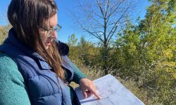 Elise Matz, standing outside, points at a map she's holding