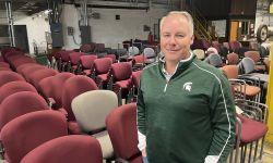 Ron Turner standing next to chairs