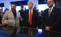 Donald Trump, wearing a dark colored suit and a red tie, stands next to Albert Abbas and Massad Boulos