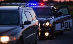 A police car and a passenger car on the side of the road