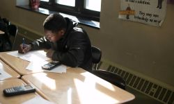 Student working at a desk in a classroom. 