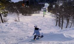 A snowboarder heads down a hill