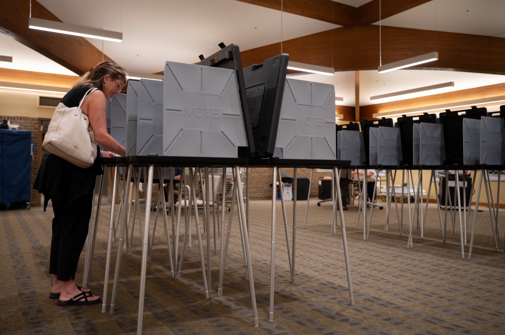 A woman casts her ballot at a polling place