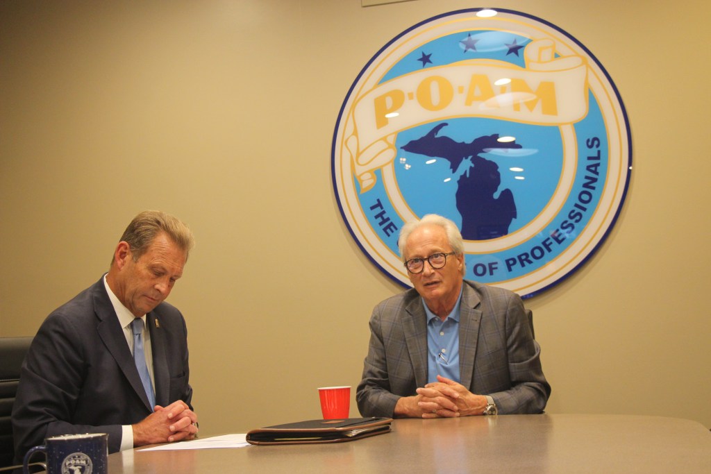James Tignanelli and Doug Lloyd sit at a table together.
