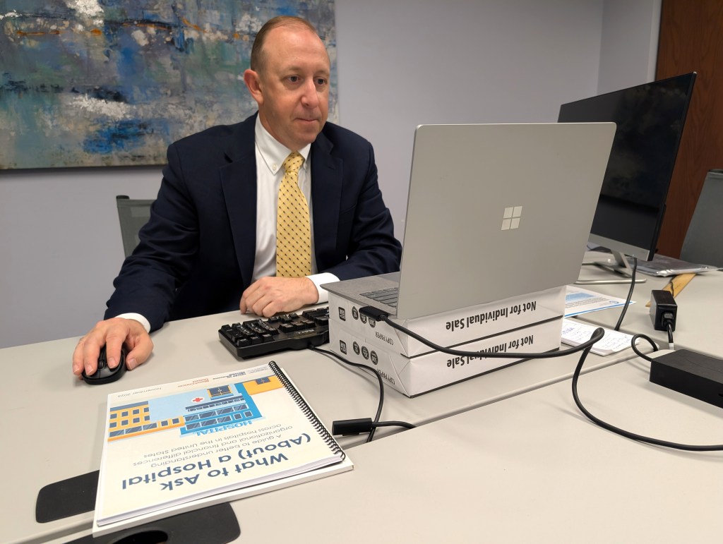 Bret Jackson sits at a desk, looking at a laptop.